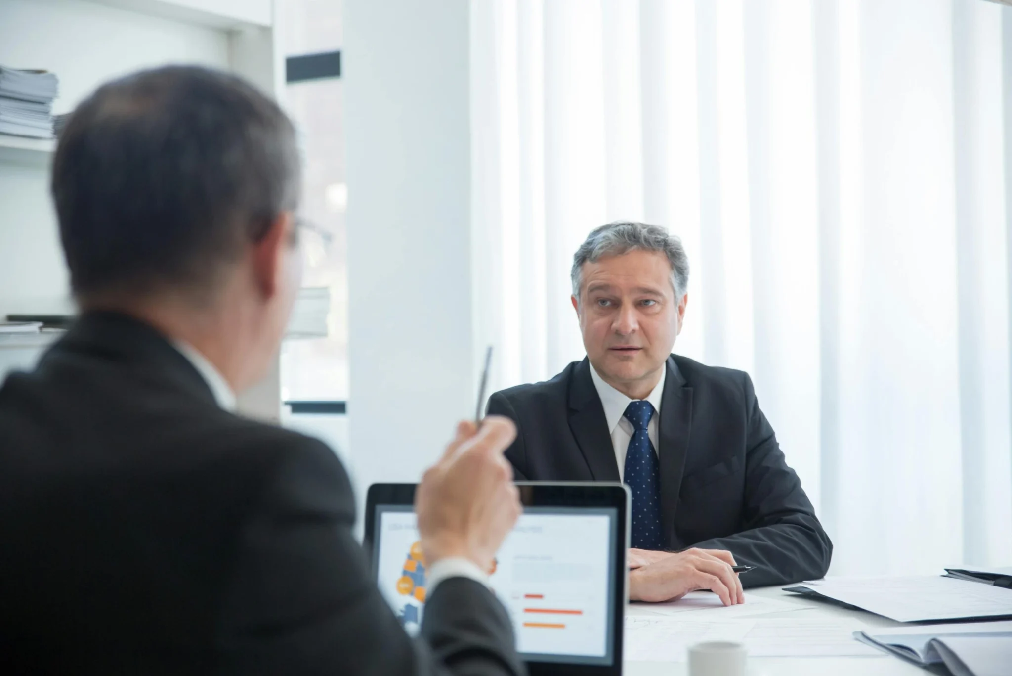 Dos empresarios conversando en una oficina.