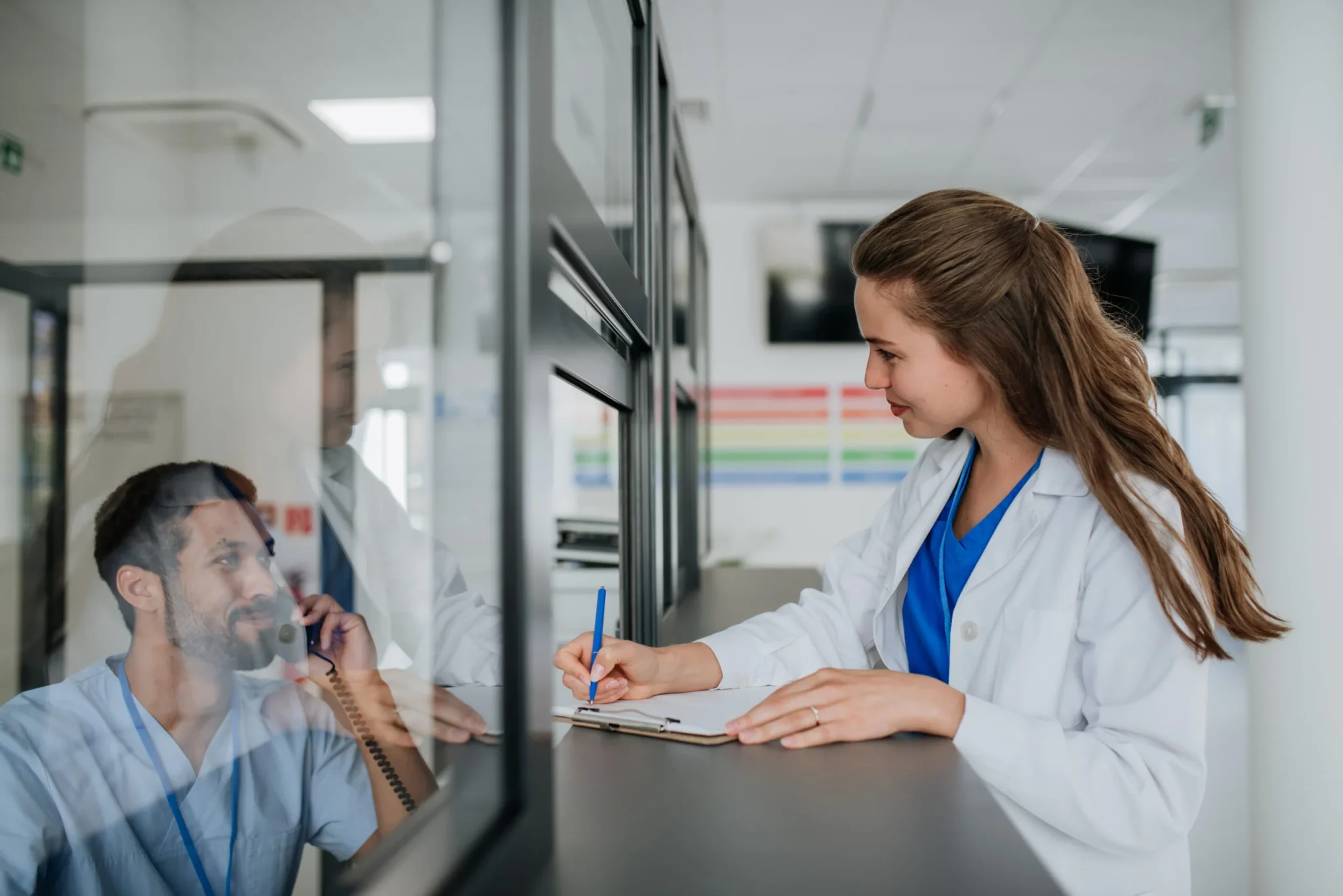 Doctora joven hablando con su colega en la recepción del hospital.