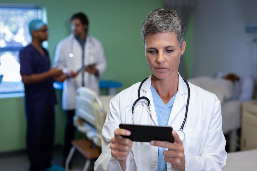 Doctora usando su teléfono móvil en una clínica del hospital.