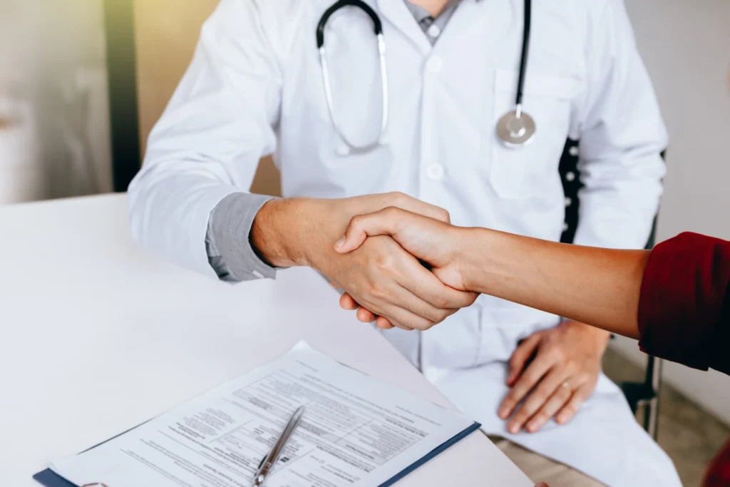 doctor estrechando manos con paciente en la clínica