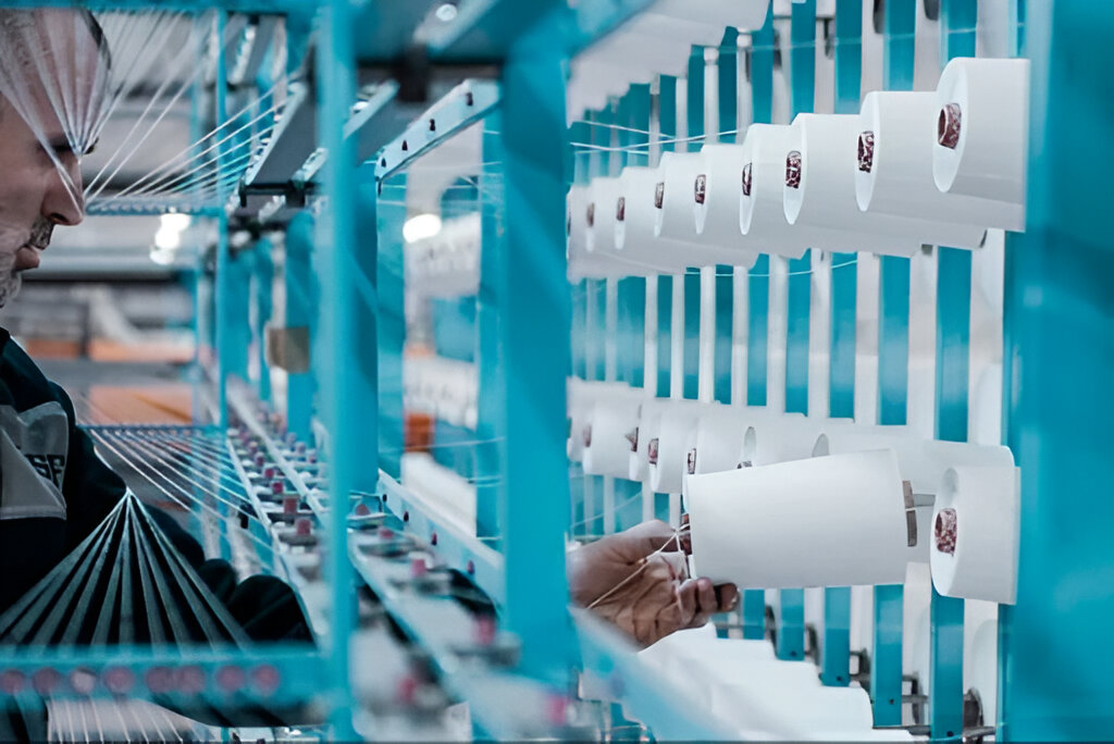 Persona produciendo hilos desde una maquina